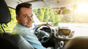 man inside the car facing at the camera