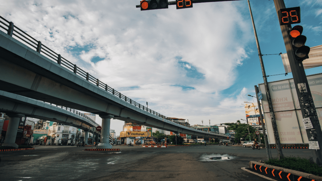 an empty street with traffic lights and an overpass