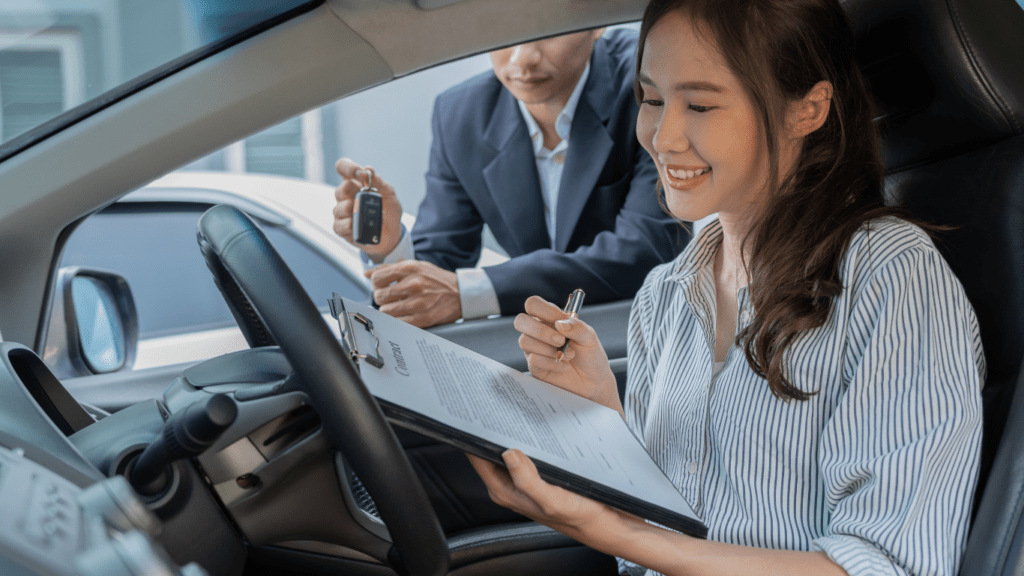 a person is sitting in the driver's seat of a car and holding a clipboard