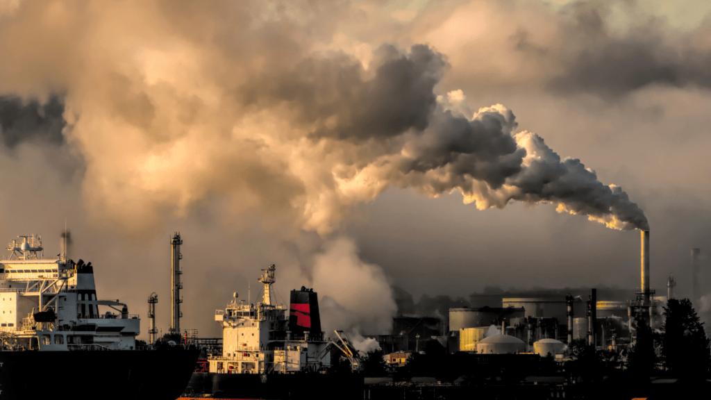 smoke billows from the chimneys of an industrial plant