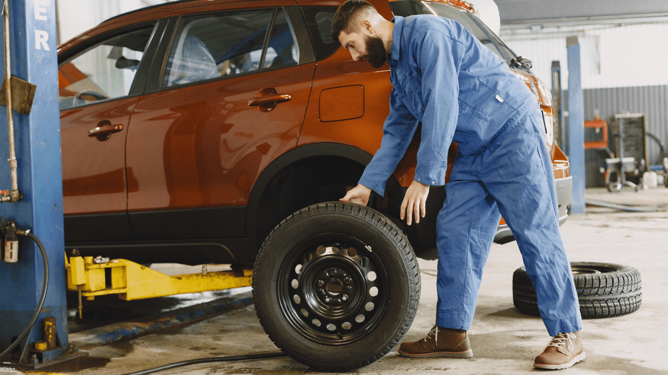 a person is changing the tire on a car in a garage