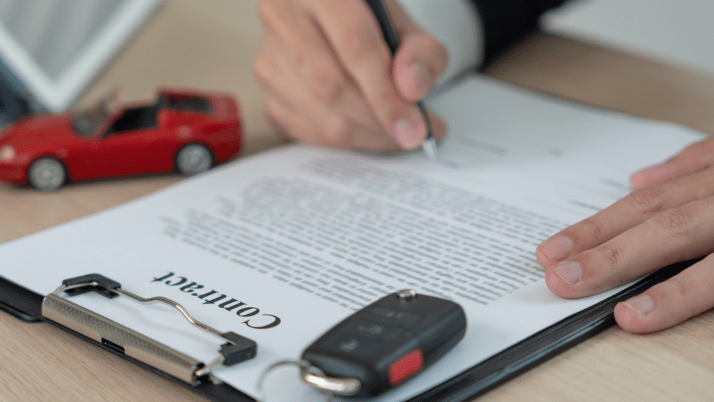 a person is signing a contract with a car in the background