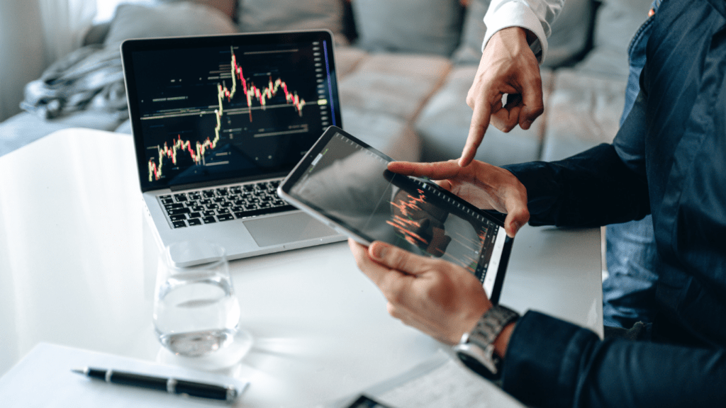 a person looking at a laptop screen with a stock chart on it