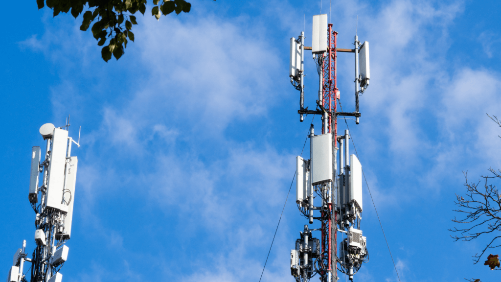 three cell phone towers against a blue sky