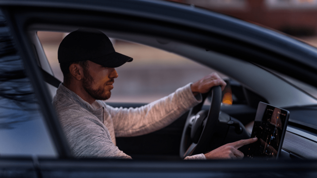 a person sitting in the driver's seat of a car with a laptop