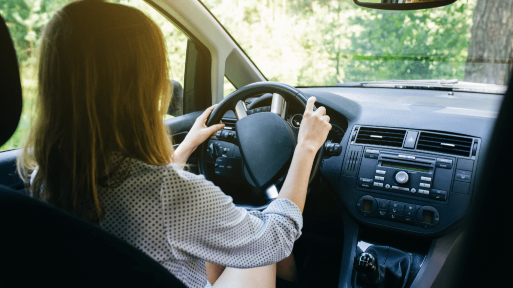 a lady driving a brand new car