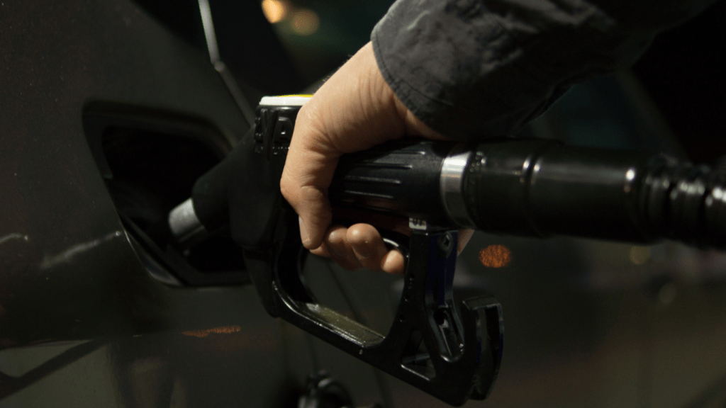 a person is pumping gas into a car at night