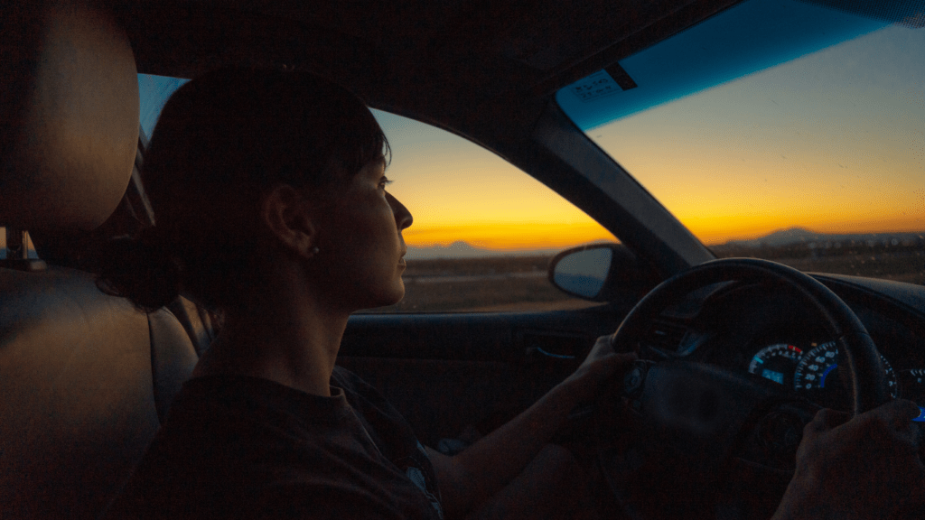 a lady driving a brand new car