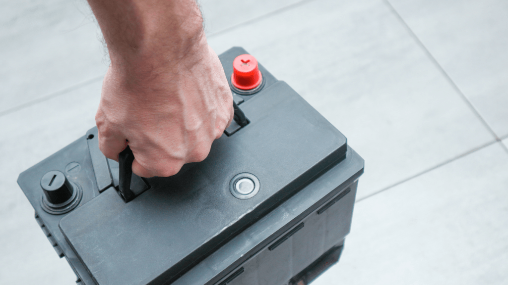 a man holding a car battery