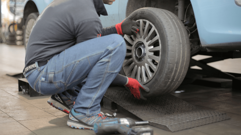 a person is changing the tire on a car in a garage