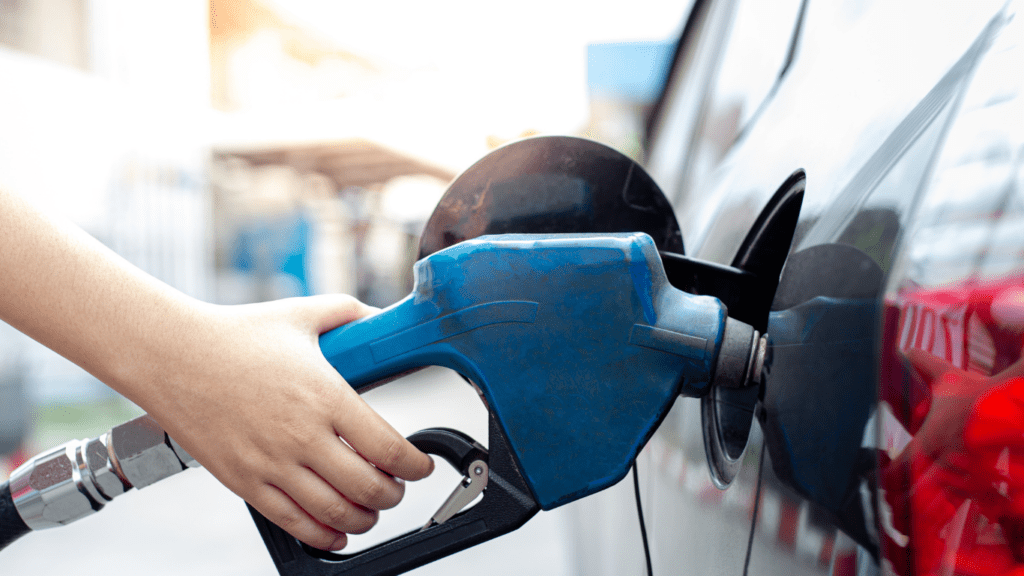 a person is pumping gas into a car at night