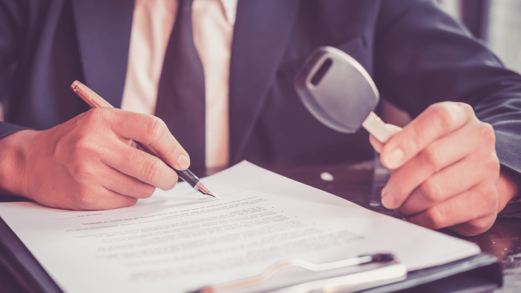 a person is signing a contract with a car in the background