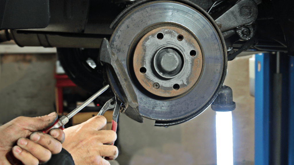 a person is working on the brakes of a car