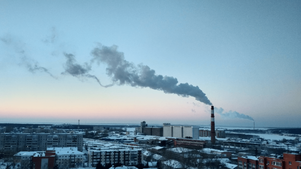 smoke billows from the chimneys of an industrial plant