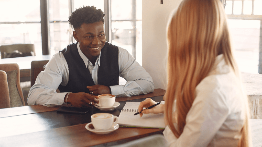 two people sitting at a table with money and a car